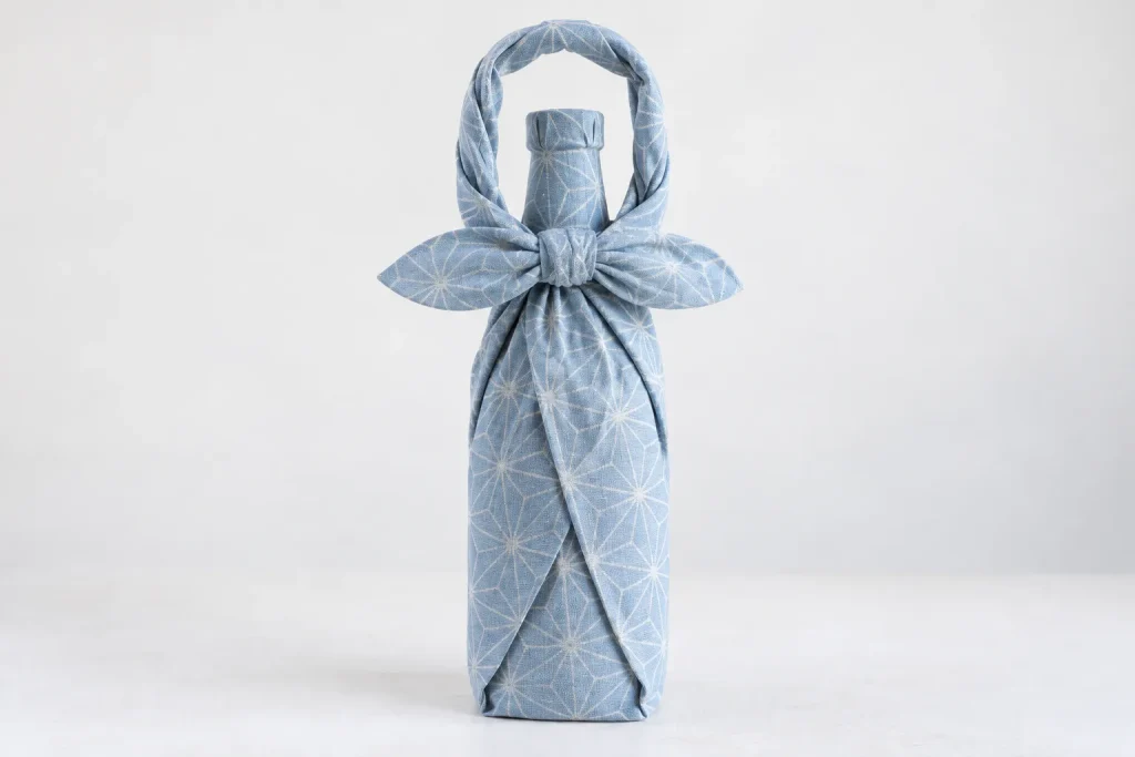 Completed single-bottle wrap with a flat ma-musubi knot forming the carrying handle