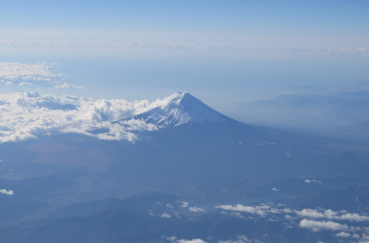 Mount Fuji above the clouds, seen from an airplane window