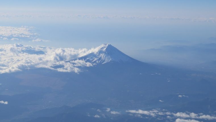 Mount Fuji above the clouds, seen from an airplane window