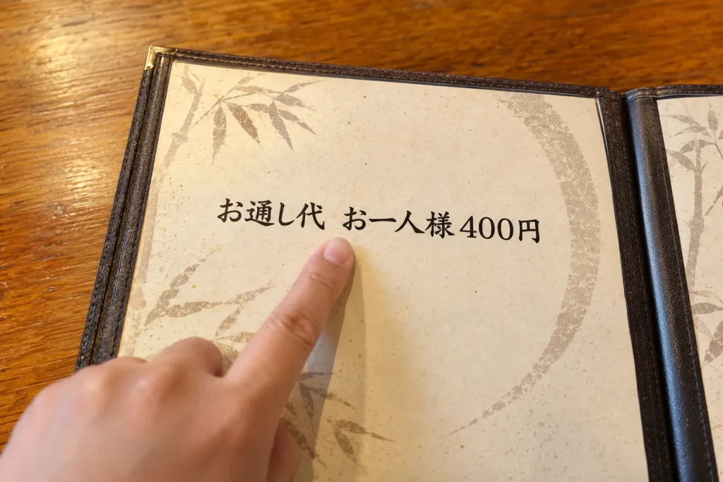 An izakaya menu showing a clearly printed per-person otoshi charge